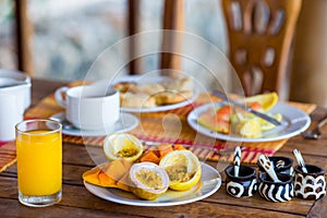 Tasty exotic fruits - ripe passion fruit, mango on breakfast at outdoor restaraunt