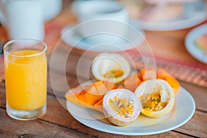 Tasty exotic fruits - ripe passion fruit, mango on breakfast at outdoor restaraunt