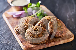 Tasty falafel pieces on wooden bread board photo