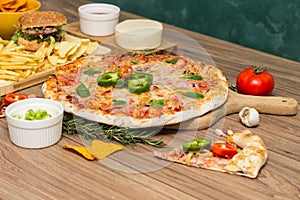 Tasty fast food on table. Pepperoni pizza and pizza Capricciosa , hamburger and potato chips