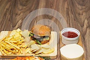 Tasty fast food on table. Pepperoni pizza and pizza Capricciosa , hamburger and potato chips