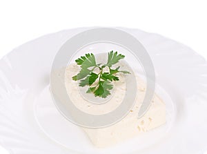 Tasty feta cheese on plate with herb.
