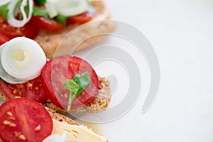 Tasty finger food of spring onions and cherry tomatoes and organic cheese with basil on baked bruschetta bread