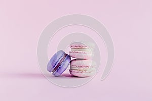 Tasty french macarons on a pink pastel background. Pink and violet macarons. Place for text