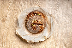 Tasty fresh baked loaf of dark bread with sesame seeds on light background