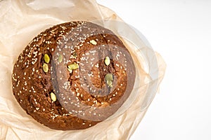 Tasty fresh baked loaf of dark bread with sesame seeds on white background