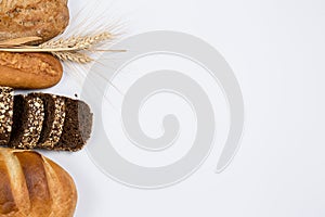 Tasty fresh black and white bread with wheat and flour on a white background