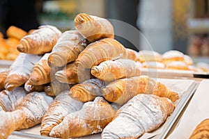 Tasty fresh croissants and rolls on a counter in shop