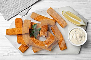 Tasty fresh fish fingers served on white wooden table, flat lay