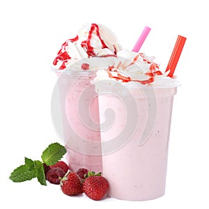 Tasty fresh milk shakes in plastic cups with ingredients on background photo