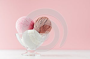 Tasty fresh set of ice cream - strawberry, chocolate, creamy in glass bowl on white wooden table and soft light pastel pink.