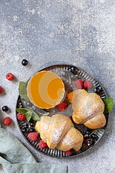 Tasty freshly baked croissants and orange juice on a grey stone background, breakfast concept photo