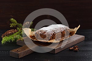 Tasty freshly baked fruit cake with fir btanch on dark background photo