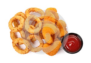 Tasty fried onion rings, chicken nuggets and ketchup on white background, top view