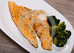 Tasty fried rainbow trout fillet with broccoli on plate