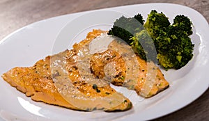 Tasty fried rainbow trout fillet with broccoli on plate