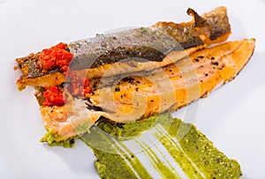 Tasty fried rainbow trout fillet with sauces on plate