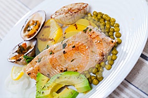 Tasty fried trout fillets, served with seashells, vegetables and avocado