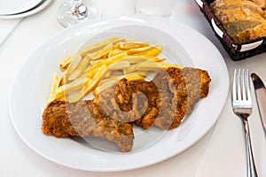 Tasty frying pork escalope served at plate with french fries