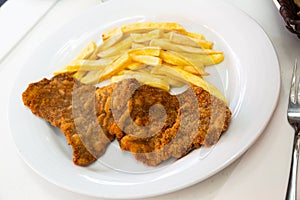 Tasty frying pork escalope served at plate with french fries