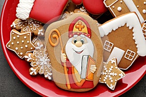 Tasty gingerbread cookies on red plate, top view. St. Nicholas Day celebration photo