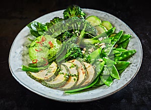 Tasty green vegetable Buddha bowl with avocado dip photo