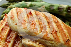 Tasty grilled chicken meat and asparagus, close up