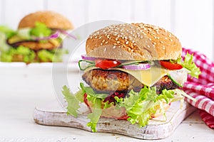 Tasty grilled homemade hamburger with burger chicken, tomato, cheese