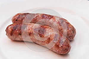 Tasty grilled meat sausages on dish