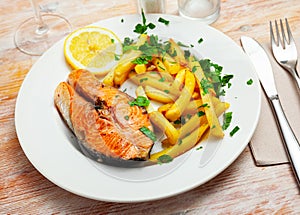 Tasty grilled salmon served with french fries