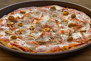 A tasty ham pizza with green olives