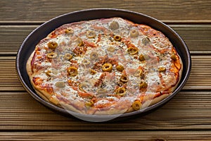 A tasty ham pizza with green olives