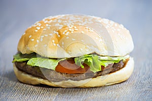 Tasty hamburger on wooden table