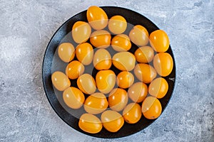 Tasty and healthy yellow ripe tomatoes on a plate.