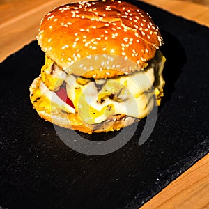 Tasty home made cheeseburger. Cheese burger with pickles, tomatoes, onion, melting cheese