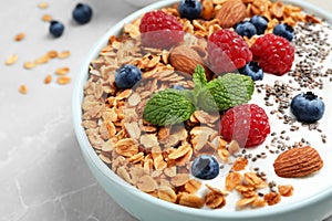 Tasty homemade granola with yogurt and berries on grey table, closeup. Healthy breakfast