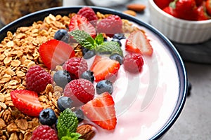 Tasty homemade granola with yogurt on grey table. Healthy breakfast