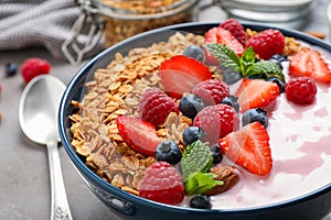 Tasty homemade granola with yogurt on grey table. Healthy breakfast