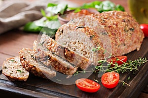 Tasty homemade ground baked turkey meatloaf on wooden table.