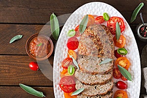 Tasty homemade ground baked turkey meatloaf on wooden table.