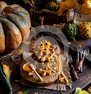 Tasty homemade pumpkin orange waffles on wooden board on brown rustic table with pumpkins