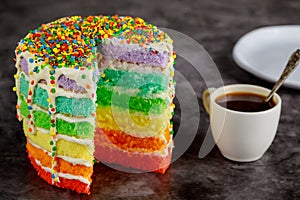 Tasty homemade rainbow cake with cup of coffee