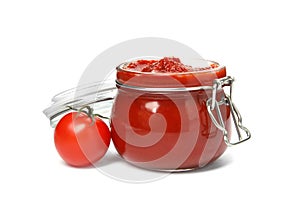 Tasty homemade tomato sauce in glass jar and fresh vegetable