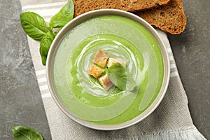 Tasty homemade zucchini cream soup served on table, flat lay