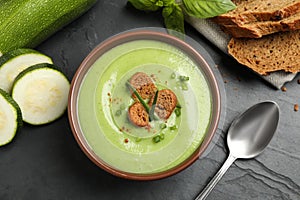 Tasty homemade zucchini cream soup served on table, flat lay