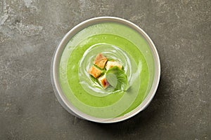 Tasty homemade zucchini cream soup on table, top view