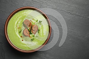 Tasty homemade zucchini cream soup on table, top view. Space for text