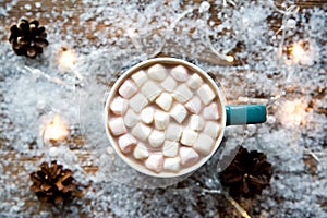 Tasty hot chocolate on snowy winter background, top view. Festive winter mood