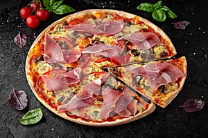 Tasty hot pizza with Bacon, Baked Pork, Tomatoes, Olives, Cheese, Feta, Mozzarella, Basil and Sauce. Pizzeria menu.