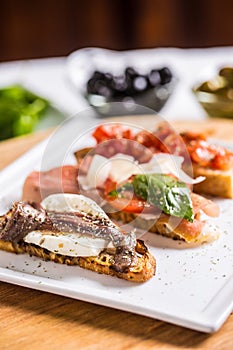 Tasty italian appetizer bruschettes with tomatoes anchovies pros